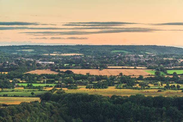 sole che sorge sopra un tradizionale complesso residenziale britannico con la campagna sullo sfondo - crop buckinghamshire hill pasture foto e immagini stock