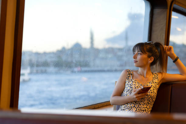 istock Young woman watching the view from the ferry window. 1585221677