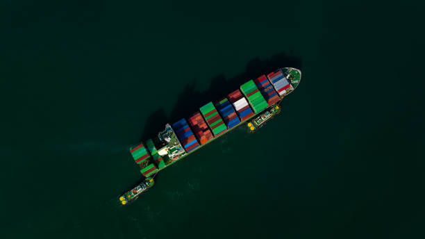 istock top view light and shadow of cargo container ship sailing in sea to import export goods and distributing products to dealer and consumers worldwide, by container ship Transport business delivery service, 1585247100