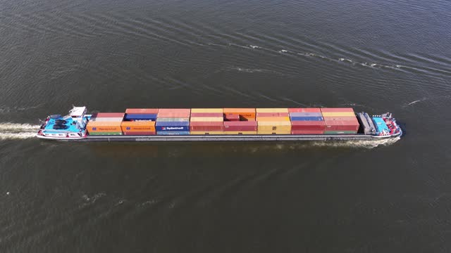 Amsterdam, 21st of June 2023, The Netherlands. Inland shipping container ship sailing. Transport logistics aerial drone view.