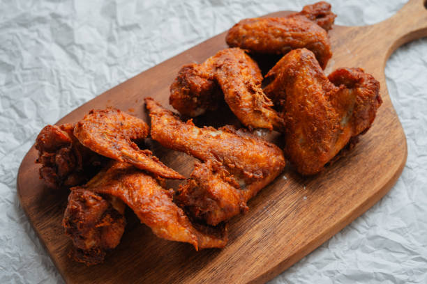istock Crispy Fried Chicken Wings Topped with Green Onions 1585256913