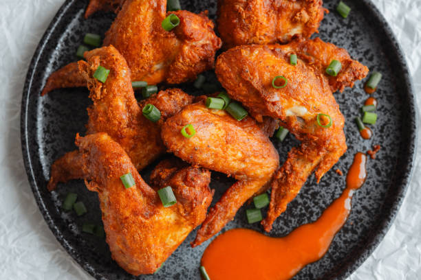 istock Crispy Fried Chicken Wings Topped with Green Onions 1585256922