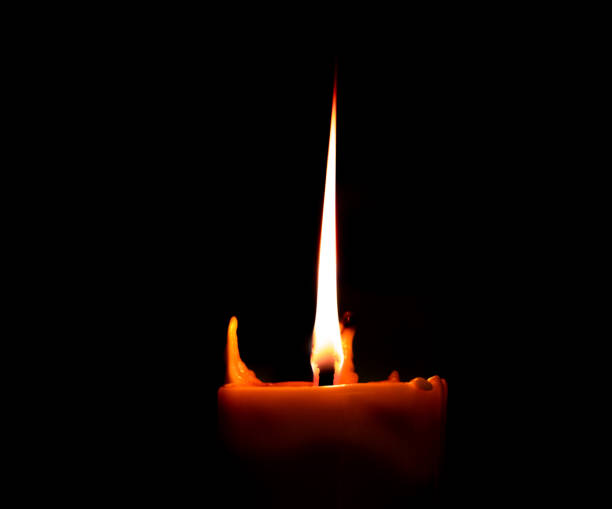 Burning big candle on dark candle holder and black background, space for text on top. Buddhism Memory day stock photo
