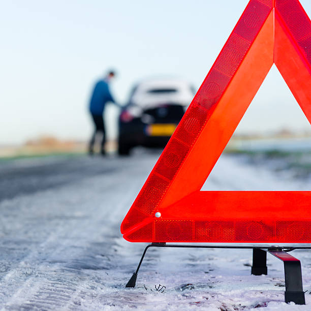istock Safety triangle in the road near a broken down car 158531407
