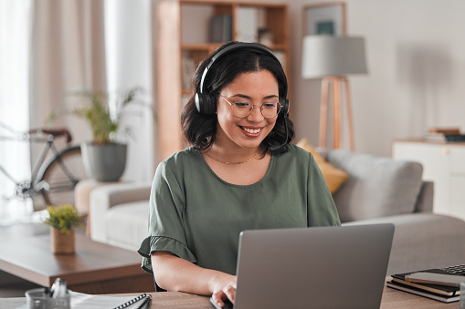 Happy, remote work and woman with a laptop for call center communication and consultation. Smile, advice and a young female customer service agent typing on a computer from a house for telemarketing