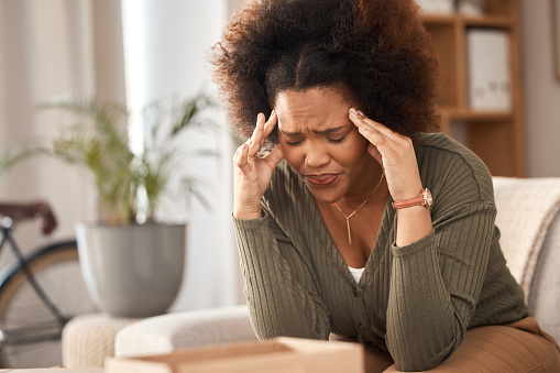 Headache, black woman and pain in home from stress, mental health problem and fatigue. Depression, sick and frustrated female with anxiety, burnout and tired from brain fog, vertigo and debt crisis