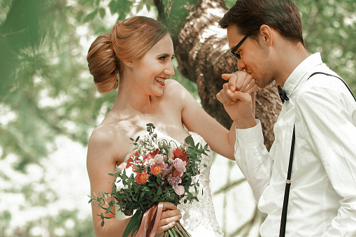 close up. the happy groom kisses his bride's hand . romantic moment