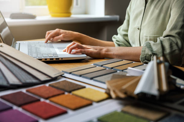 istock interior designer working on laptop in office. design material samples on desk 1585334985