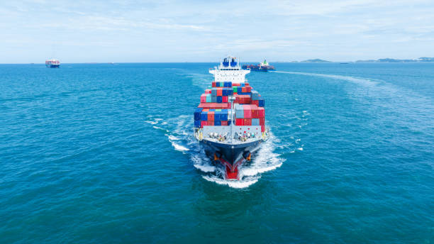 istock Aerial side view of smart cargo ship carrying container from customs container depot go to ocean concept freight shipping by ship service on blue sky .Freight Forwarding Service 1585338628