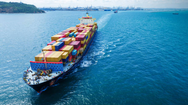 istock Aerial side view of smart cargo ship carrying container from customs container depot go to ocean concept freight shipping by ship service on blue sky .Freight Forwarding Service 1585339134