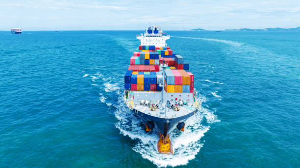 istock Aerial side view of smart cargo ship carrying container from customs container depot go to ocean concept freight shipping by ship service on blue sky .Freight Forwarding Service 1585339146