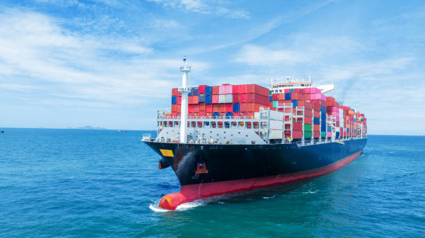 istock Aerial side view of smart cargo ship carrying container from customs container depot go to ocean concept freight shipping by ship service on blue sky .Freight Forwarding Service 1585339149