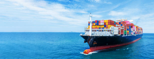 istock Aerial side view of smart cargo ship carrying container from customs container depot go to ocean concept freight shipping by ship service on blue sky .Freight Forwarding Service 1585339153