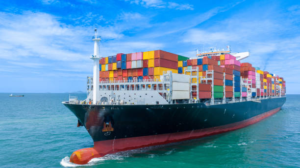 istock Aerial side view of smart cargo ship carrying container from customs container depot go to ocean concept freight shipping by ship service on blue sky .Freight Forwarding Service 1585339672