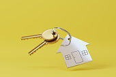 House shaped keychain isolated on yellow background. 3d illustration.