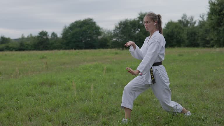 Teenage girl practicing karate on the meadow