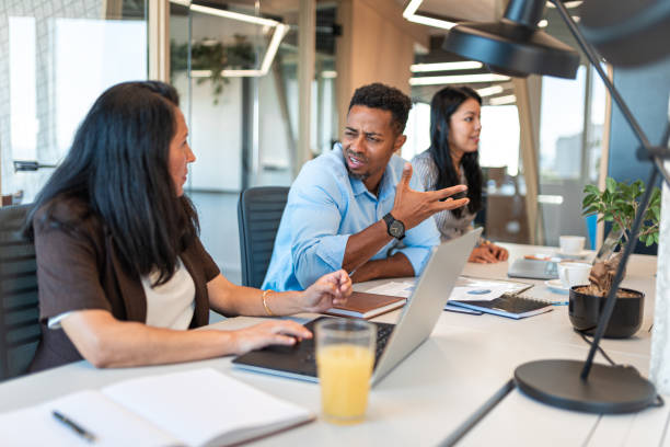 istock Two colleagues sitting at the table in office and talking 1585363478