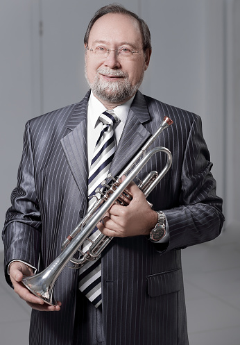 Portrait of a man in a gray suit with a trumpet