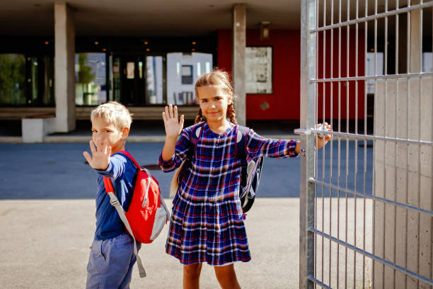 istock Back to school. Siblings with backpacks going to school from home at their first day after vacation 1585375438