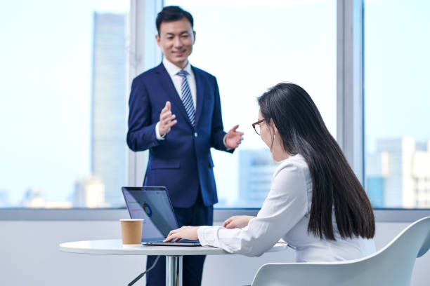 istock Two Asian Business People Working at Office Room 1585389178