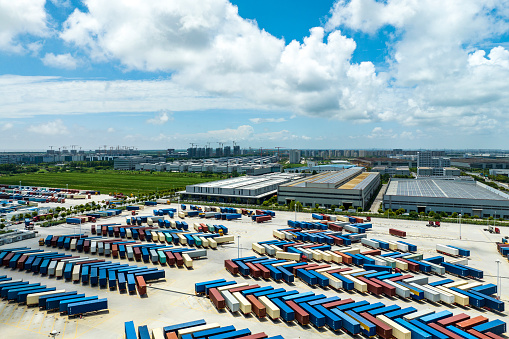 Aerial view of a distribution warehouse with truck and containers and road at Shanghai free trade zone,china.Top down shot looking directly down on rows of truck trailers and shipping containers, ready to be transferred between road and rail modes of transport.