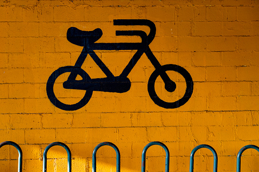 Bicycle parking sign on a yellow wall