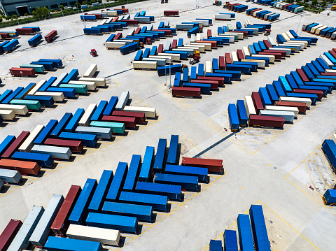 Aerial view of a distribution warehouse with truck and containers and road at Shanghai free trade zone,china.Top down shot looking directly down on rows of truck trailers and shipping containers, ready to be transferred between road and rail modes of transport.