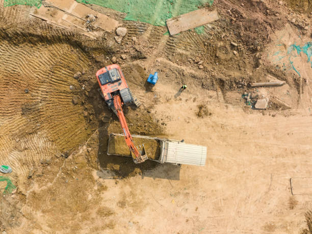 istock Excavator on earthmoving with grab crane unloads sand from freight car 1585401249
