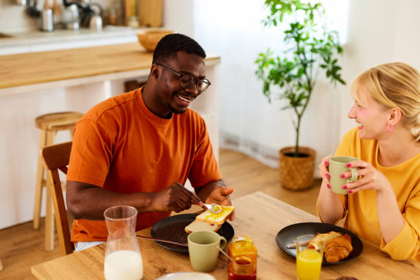 istock Multiracial couple enjoying breakfast together at home 1585412853