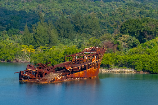 A rusty, stranded and sunken shipwreck vessel.