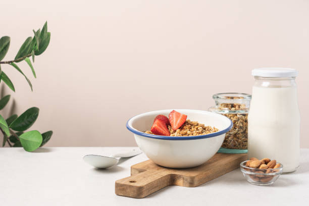 istock Granola in bowl with strawberries on light background with copy space. 1585416072