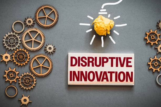 istock Disruptive innovation text on wooden block. Between gears, precision mechanisms and drawn light bulb, business concept 1585426048