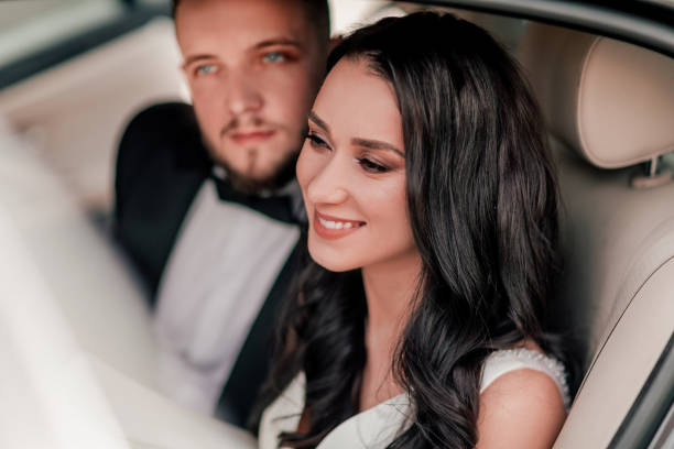 aufschließen. ein glückliches brautpaar sitzt im auto. - bride caucasian wedding ceremony close up stock-fotos und bilder