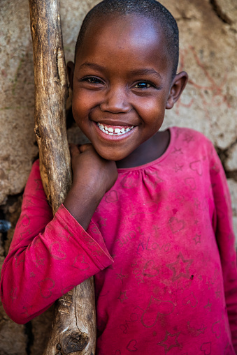 Portrait of African little girl from Masai tribe, on savanna. Maasai tribe inhabiting southern Kenya and northern Tanzania, and they are related to the Samburu.