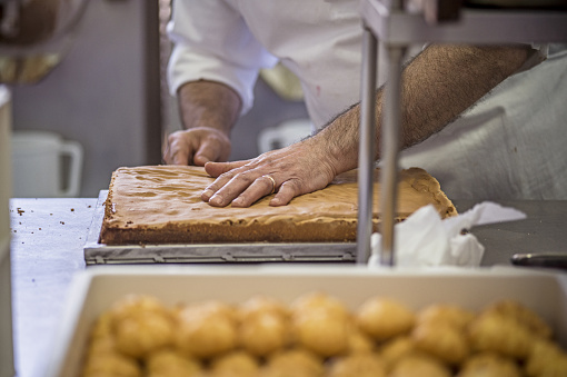 Production of delicious desserts and cakes with cream, and strawberries in a confectionery factory in Sicily, Italy.