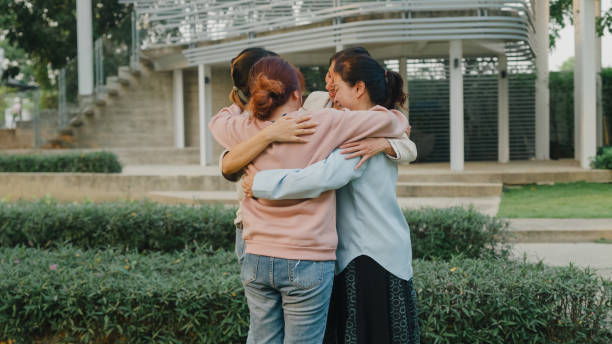 istock Group therapy session with diverse people sharing their sad problems and stories in park. Asian people group in circle comforting together hope for help. Mental health. 1585443274