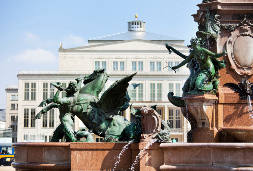Detail of the famous Mende fountain in Leipzig, Germany. Leipzig Opera House in the background.