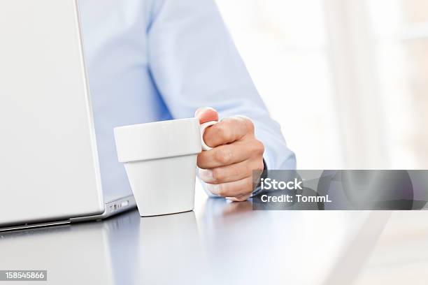 Ein Mann Im Blauen Hemd Holding Auf Die Cup Und Computer Durchsuchen Stockfoto und mehr Bilder von Arbeiten