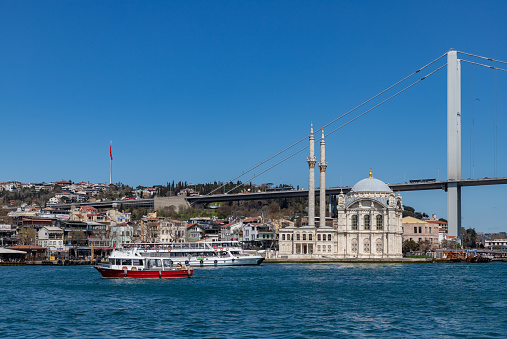 Istanbul, Turkey - April 8, 2023: A picture of the Ortakoy Mosque, the Bosphorus Bridge, and some ferries.