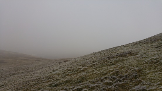 Tranquil misty hilltop amidst natural scenery. Misty view of Pen y Fan, South Wales.