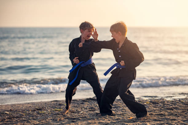Little boys practicing kung fu on the beach. Boys are fighting.Show with Nikon D850