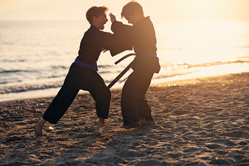 Little boys practicing kung fu on the beach. Boys are fighting.
Show with Nikon D850