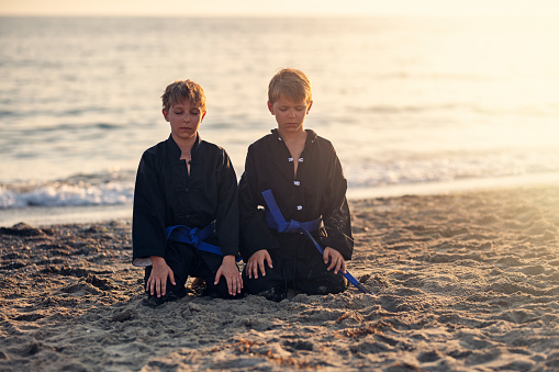 Little boys practicing kung fu on the beach. Boys are sitting with eyes closed.
Show with Nikon D850