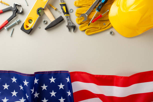 istock Construction-themed Labor Day festivity: Ignite interest with this top-down snapshot, featuring a flag, work helmet, gloves and tools on a light grey backdrop. Ideal for Labor Day promotions or ads 1585528150