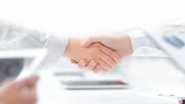 close up. handshake of financial partners after signing the contract . business concept