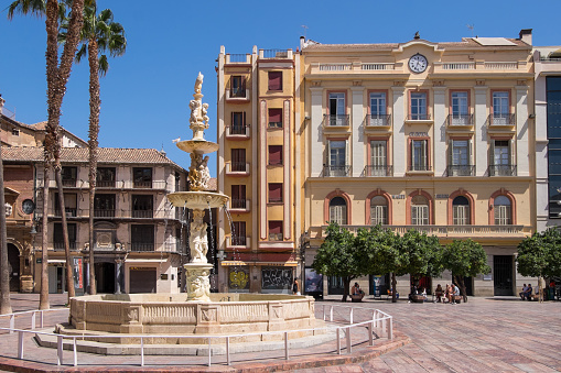 Malaga, Andalusia, Spain - July 30, 2023: Genoa Fountain and Constitution Square in the urban center of the city