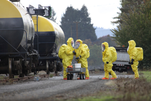 In any urban area the fire departments and emergency response teams will conduct disaster preparedness drills. These HAZMAT team members are suited up with a protective suit to protect them from hazardous materials as they investigate this mock railroad disaster.