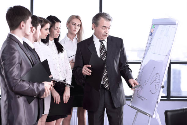 businessman pointing with pen on the flipchart stock photo