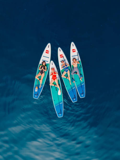 21. juni 2022. dalaman, türkei. luftaufnahme einer weiblichen gruppe auf stand-up-paddle-board am blauen meer. mädchen meditieren auf rotem paddel-sup-board im ozean. - editorial women paddleboard surfboard stock-fotos und bilder