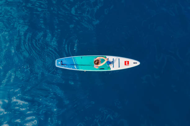 21. juni 2022. dalaman, türkei. luftaufnahme einer frau auf stand-up-paddle-board auf see. frau auf rotem paddel-sup-board im ozean. - editorial women paddleboard surfboard stock-fotos und bilder